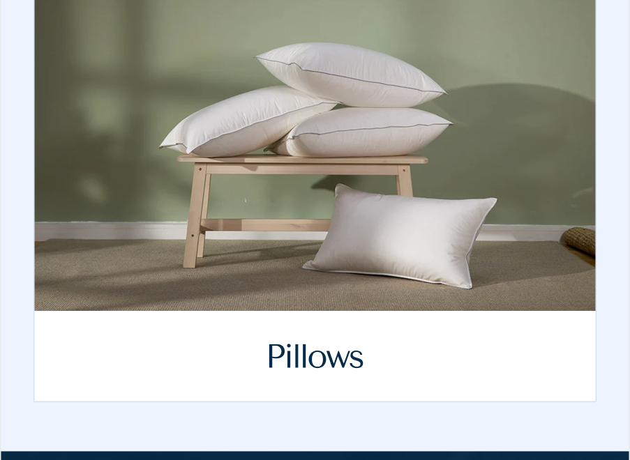 Four crisp white, lofty down pillows styled beautifully